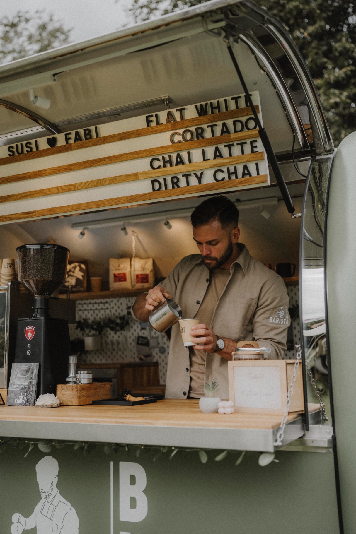 Julian bereitet Kaffee im Barista-Wagen zu